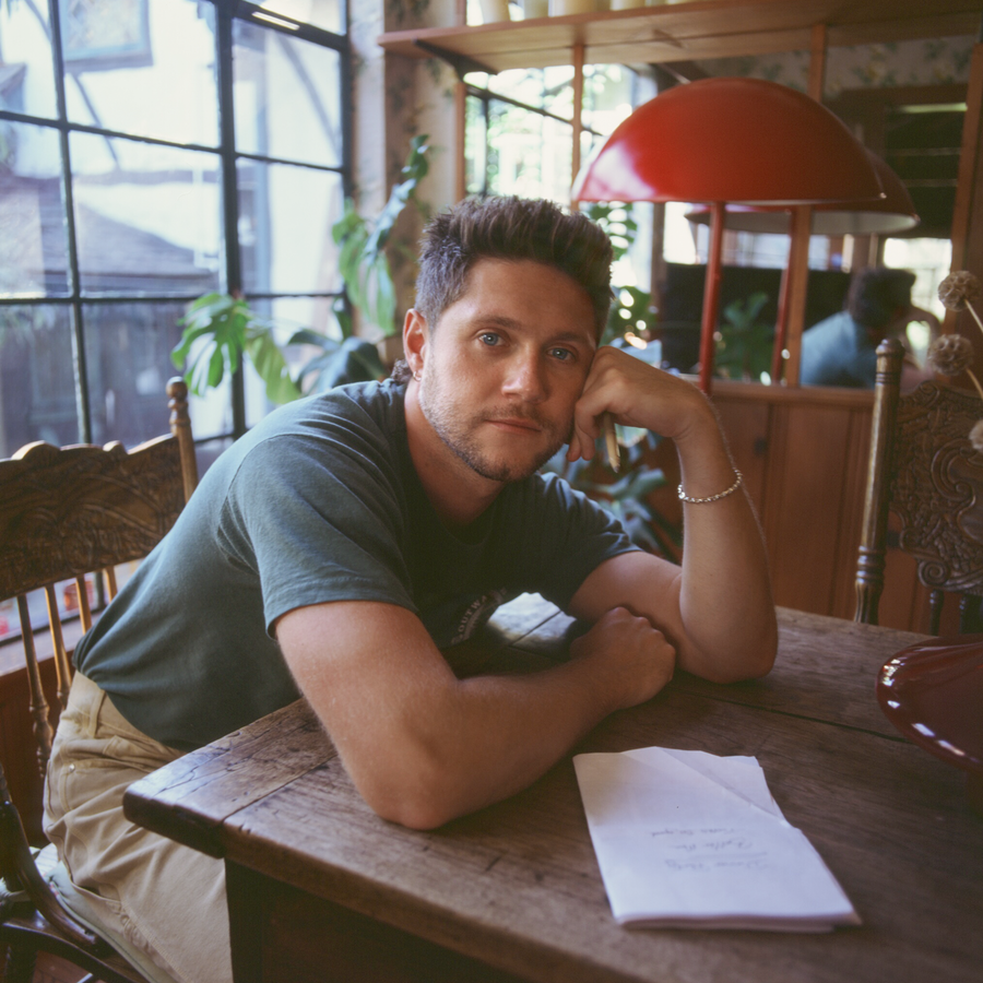 Nial Horan sitting at a desk with a paper